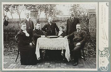 Lehrer sitzen im Garten an einem Tisch